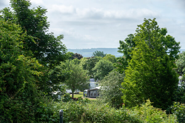View of St Helens caravan park with green trees and moors in the distance