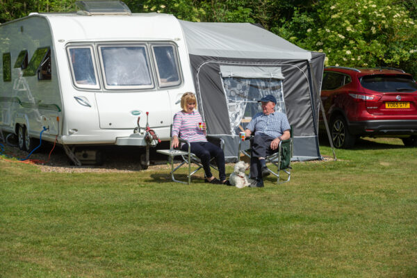 A couple relaxing in front of their caravan